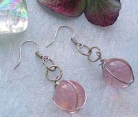 Double loop fashion earring with wired-in transparent pinkish glass bead suspended