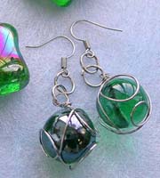 Double loop fashion earring with wired-in transparent dark or light green glass bead suspended 