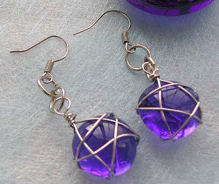 Designers fashion jewelry, fashion earring with wired-in star transparent dark blue glass bead suspended