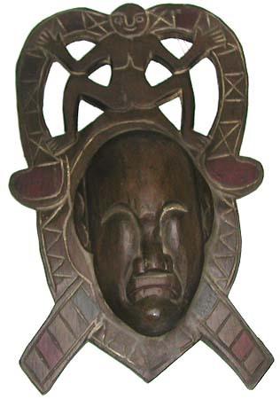 Indonesia gift art - black mad man face wooden mask with tribal man figure sitting on top 