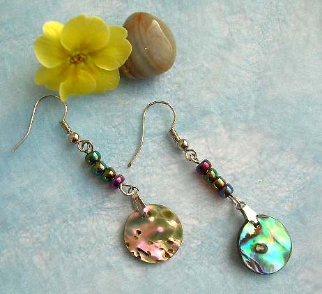 Fashion earring with beaded strip holding a circular abalone seashell on bottom